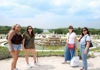 A tour group taking pictures in front of the fountain in the gardens of Versailles with The Tour Guy.