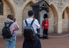 Girl and boy taking photo of Queens Guard 