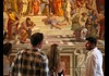 A group of tourists looking at the School of Athens with their guide from The Tour Guy.