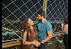 A couple on the Eiffel Tower's 2nd level at night.