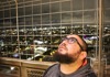 A man standing on the 2nd level fo the Eiffel Tower at night.