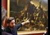 A tour guide next to the Raft of Medusa in the Louvre Museum.