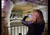 Woman taking picture of secret room at the catacombs in Paris
