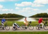 A family riding bicycles along the Grand Canal of Versailles with their guide from The Tour Guy.