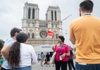 A group of tourists in front of the Notre Dame Cathedral listening to a guide from The Tour Guy.