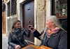Two women at a table in Venice drinking wine while on tour with The Tour Guy.