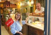 A tour guide inside a restaurant with various foods on display while giving a tour for The Tour Guy.