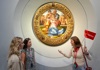 Two woman in front of Michelangelo's Holy Family in the Uffizi Gallery with their guide from The Tour Guy.