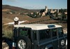 woman and jeep with village in background