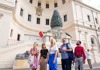 A group of tourists walking through the Pinecone Courtyard with their guide from The Tour Guy.