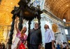 A pair of tourists in front of Bernini's Baldacchino in St. Peter's Basilica with their guide from The Tour Guy.