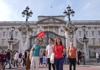 A group of tourists in front of Buckingham Palace with their guide from The Tour Guy.