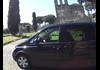An image of a van in front of ancient ruins in Rome.