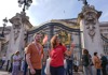 A man standing in front of Buckingham Palace with his guide from The Tour Guy.