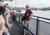 A group of tourists waiting in line to board the Thames River Boat.