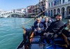 A family sitting on a gondola in Venice.
