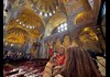 A woman taking a picture of the golden ceiling inside St. Mark's Basilica while listening to a guide from The Tour Guy.