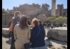 A group of tourists walking through the Roman Forum.