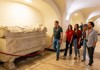 A group of tourists walking through the Papal Crypts while on tour with The Tour Guy.