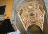 A woman taking a picture of the Golden Staircase inside the Doge's Palace.