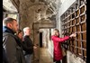 A group of tourists looking at a prison cell in the Doge's Palace dungeons and listening to a guide from The Tour Guy.