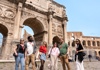A group of tourists standing under the Arch of Constantine with their guide from The Tour Guy.