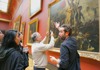 A group of tourists in the Louvre Museum and learning about Liberty Leading the People while on tour with The Tour Guy.