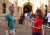 A man standing in front of the entrance to the Crown Jewels in the London Tower while speaking to his guide from The Tour Guy.