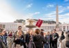 A group of tourists standing in St. Peter's Square with their guide from The Tour Guy.