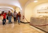 A group of tourists walking through the Papal Crypts while on tour with The Tour Guy.