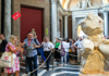 A group of tourists looking at the Belvedere Torso inside the Vatican Museums with their guide from The Tour Guy.