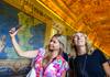 Tourists taking a selfie inside of the Hall of Tapestries.
