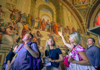 A group of tourists looking at the School of Athens while on tour with The Tour Guy.