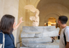 A man looking at the Winged Victory in the Louvre Museum with his guide from The Tour Guy.