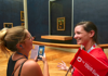 A woman in the Louvre taking a photo of the Mona Lisa while listening to their guide from The Tour Guy.