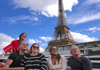 Customers with a tour guide on a boat on the Seine River in Paris in front of the Eiffel Tower.