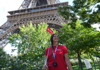 A tour guide standing in front of the Eiffel Tower in Paris.
