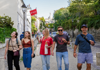 A tour group walking in Paris while eating a baguette with their guide from The Tour Guy.