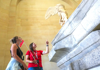 A woman on tour looking at the Winged Victory statue in the Louvre Museum with her guide from The Tour Guy.